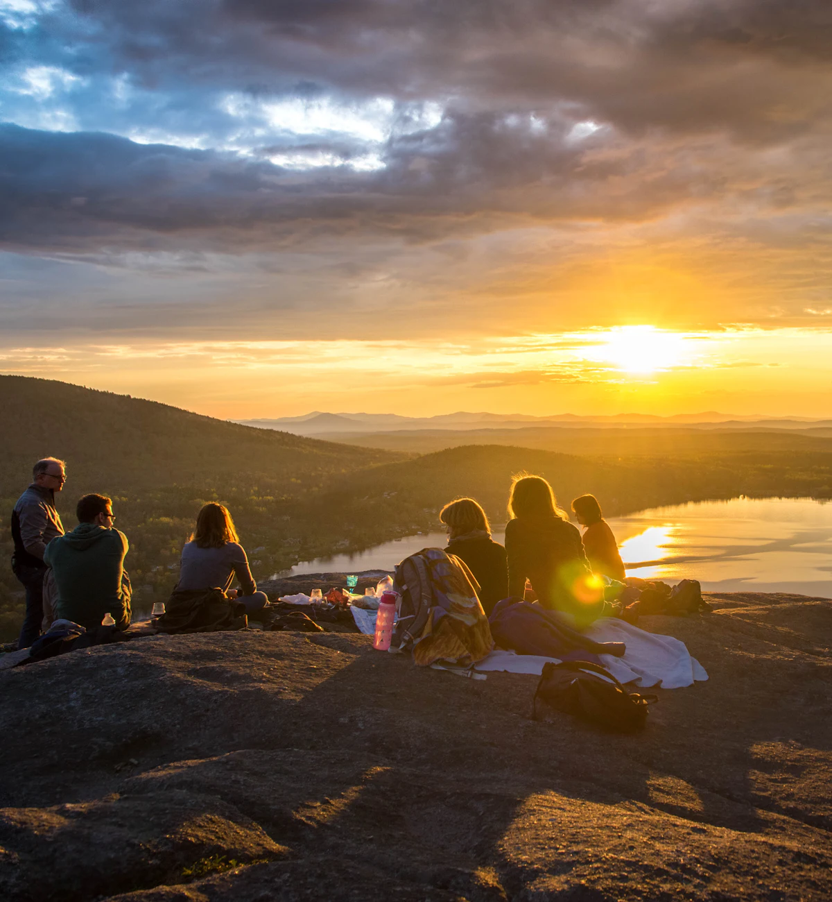 Friends watching the sunrise together over a lake